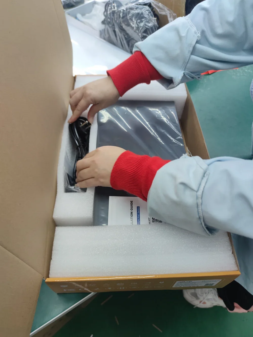 Operator packing a switch with protective inserts, accessories and installation guide